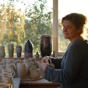 Sarah Welch, the potter, doing wipe down for her ceramics shop
